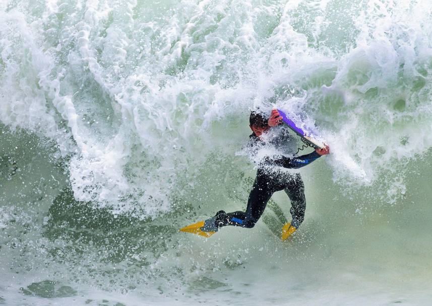 Un bodyboarder viene spazzato via da un’ondata durante una gara a Kalk Bay, Citt del Capo (Epa)